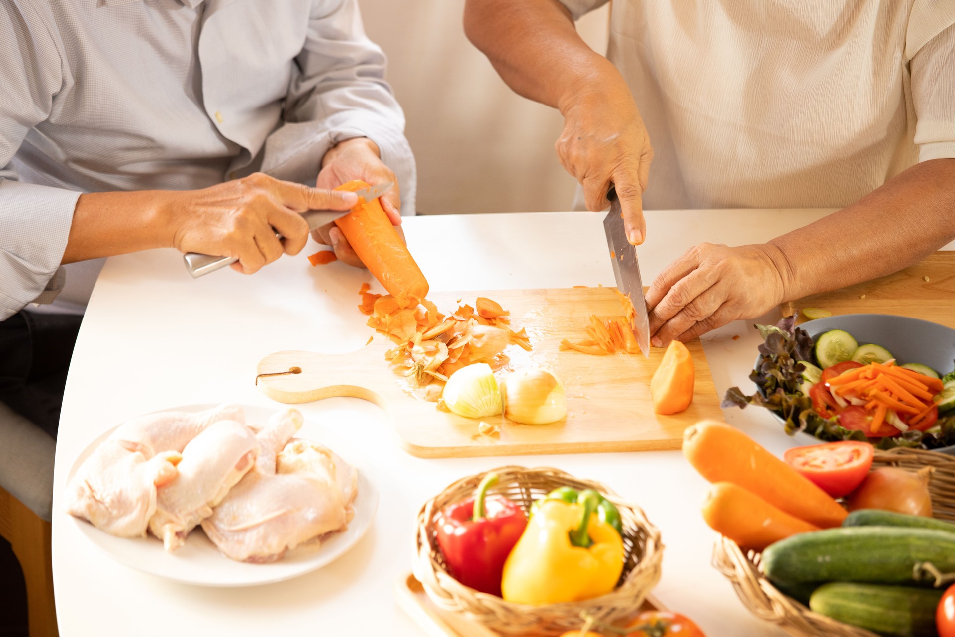 Closeup of female hands chopping fresh vegetables on chopping board while in kitchen