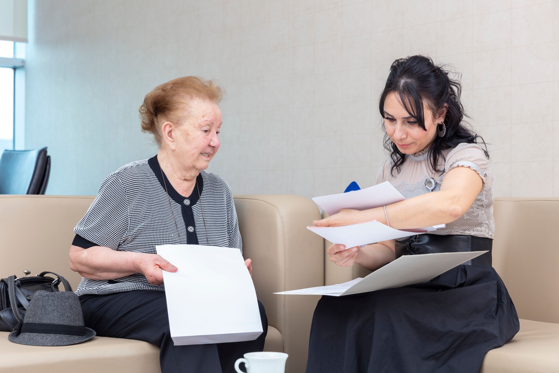 Elderly woman receives information from hospital client director.